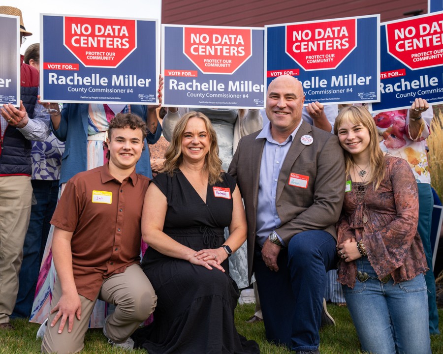 Rachelle Miller, her family, and supporters holding No Data Centers campaign signs
